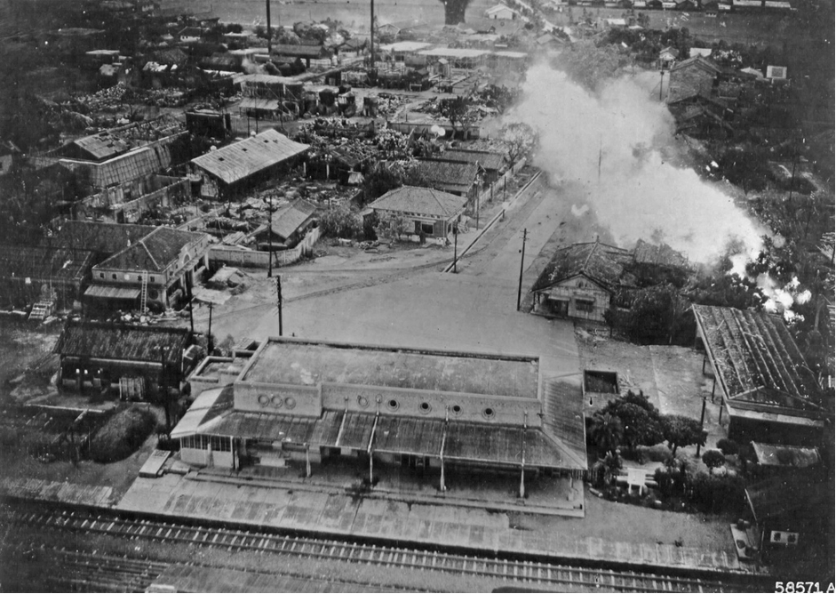 圖三 1945年5月26日，執行轟炸任務中的美軍B-25J被日軍的地面火炮擊中，因此墜毀在苗栗驛（苗栗火車站）附近（圖中右上方），該照片由美軍的同僚機攝下。（ 來源：George Lane，CC BY-NC-SA 2.0）