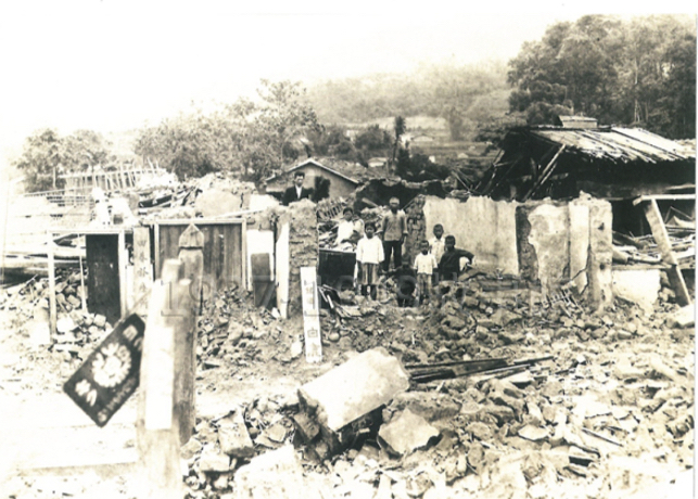 圖二 1935年的大地震，獅潭鄉有45人喪生。我們家在瓦礫堆中接受庄役場人員調查拍照。地震後獅潭地區住家幾乎全面改用防震較好的木結構，只有畜欄仍繼續使用土磚建築。（蘇耀靈提供，獅潭村史博物館）